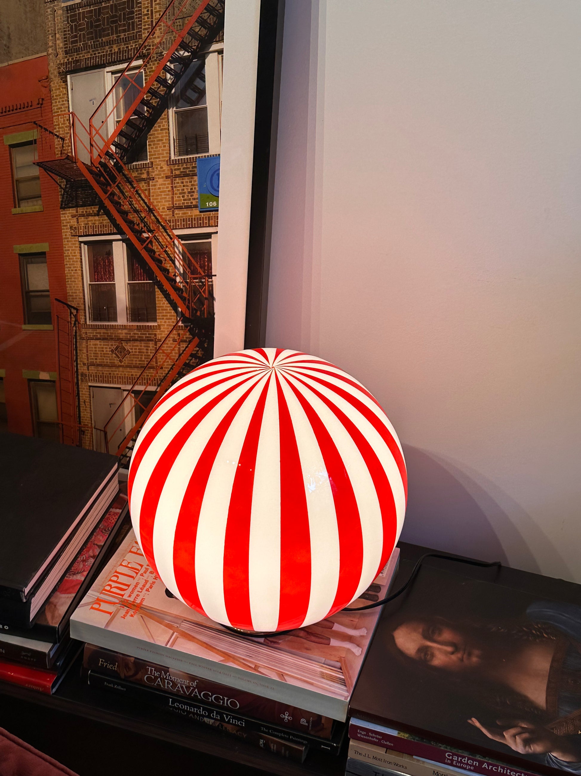 Luca - Lucy’s Lamps is a bold red and white striped globe table lamp with a retro vibe. Perfect as a modern table lamp, aesthetic desk lamp, or bedside lamp. Ideal for vintage light fixtures, retro lamps, table lamps for bedroom, and modern lamp for living room setups.