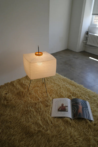 The Akari Shikaku - Lucy’s Lamps is a modern paper lantern floor lamp inspired by Japanese artistry. This minimalist lamp features a tripod base and soft diffused light, perfect for bedrooms, living rooms, or corners. Combining modern designer lighting with vintage elegance, this aesthetic lamp enhances any home as a cozy bedside lamp or stylish modern floor lamp.