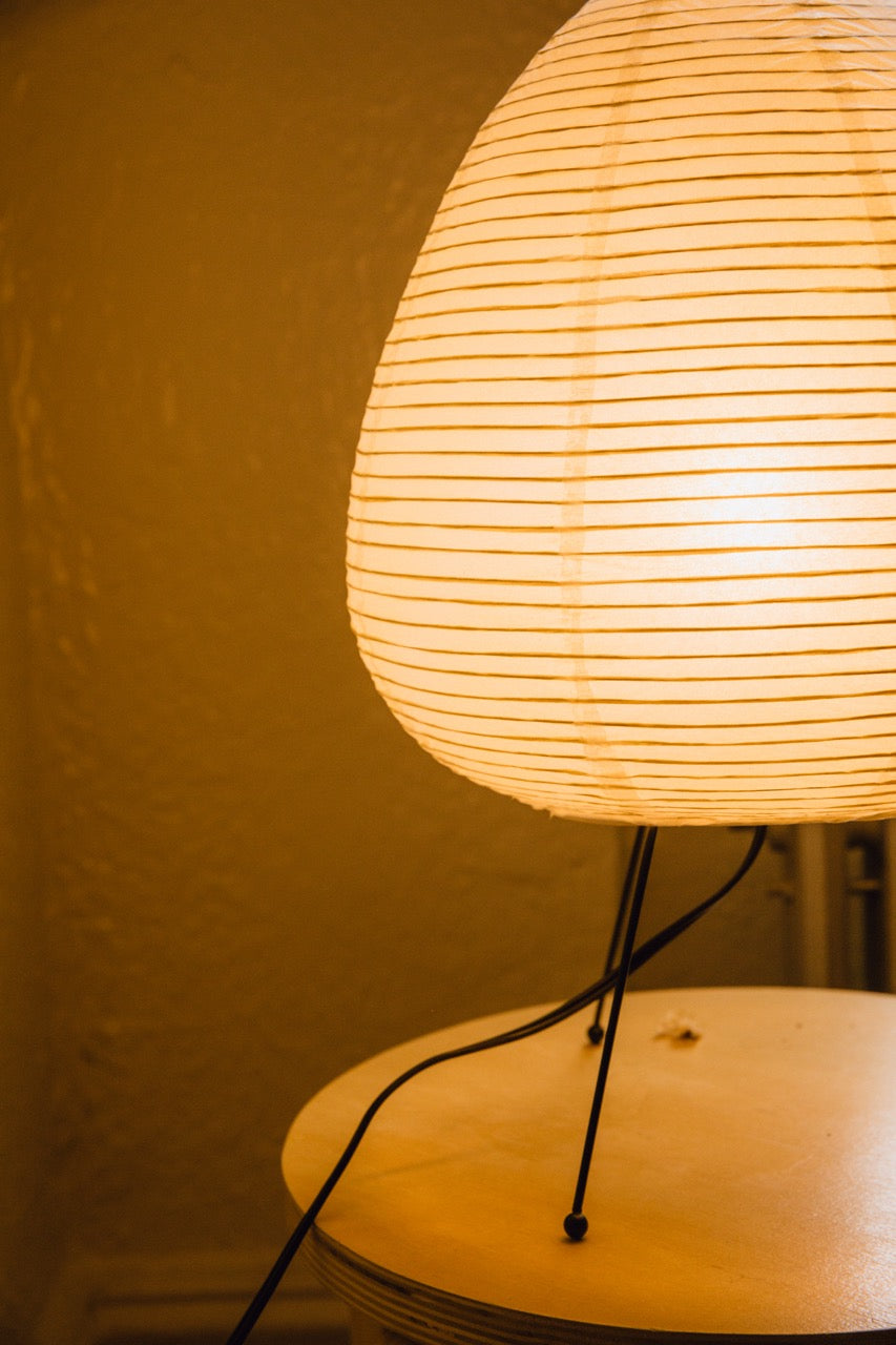 The Akari Suiteki - Lucy’s Lamps is a minimalist paper lantern table lamp inspired by Japanese design. This aesthetic and modern table lamp adds a warm glow to bedrooms, living rooms, or workspaces. Perfect as a bedside lamp, side table lamp, or desk lamp, it blends retro charm and modern designer lighting for elegant, timeless home décor.